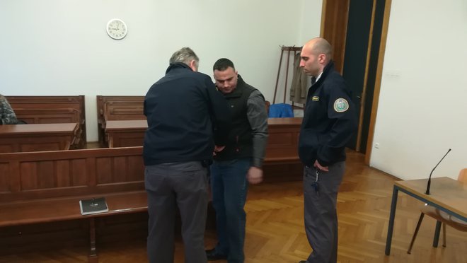 Pravosodna policista sta obtoženega pripeljala iz pripora. FOTO: Aleš Andlovič