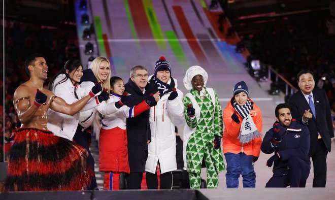 Športniki, med njimi Pita Taufatofua iz Tonge (skrajno levo) in Američanka Lindsey Vonn (tretja z leve), so se fotografirali s predsednikom MOK Thomasom Bachom (peti z leve). Foto: AP