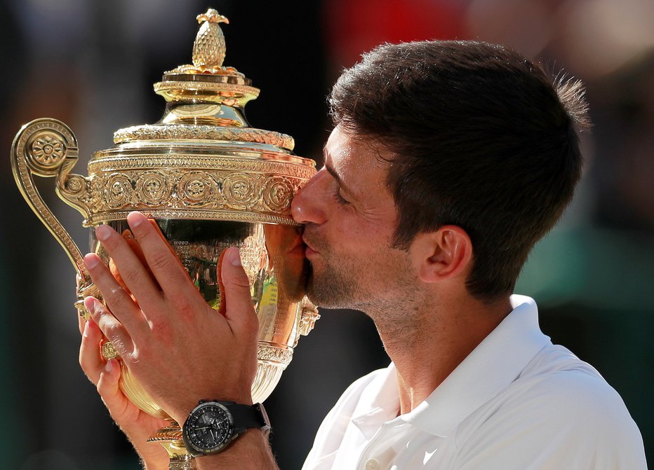 Fotografija: Trofeja za wimbledonsko zmago je tako očarljivo sladka, da se niti Novak Đoković ni mogel upreti, da je ne bi poljubil. FOTO: Reuters