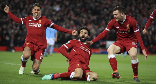 Napadalec Liverpoola Mohamed Salah, v sredini, je proslavil uvodni zadetek z Robertom Firminom, levo, in Andrewom Robertsonom. Foto: AP