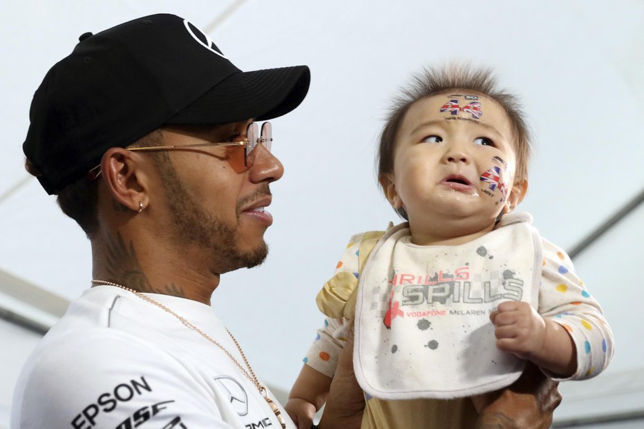 Fotografija: Lewis Hamilton z enim svojih najmlajših navijačev na Japonskem FOTO: AP