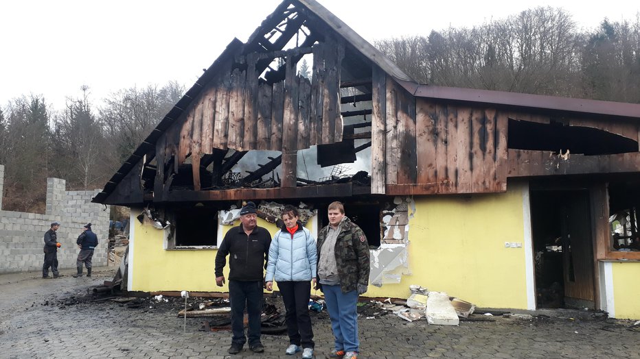 Fotografija: Vlado, Majda in Kivi Jurše pred ožgano hišo, ko je ta še stala. Zdaj je že ni več. FOTO: Občina Šmarje