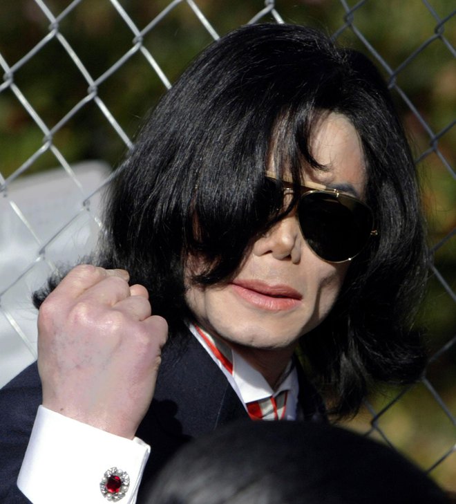 Michael Jackson gestures to fans outside the Santa Maria, California courthouse after his arraignment on child molestation charges January 16, 2004. Jackson pleaded innocent to child molestation charges on Friday during a hearing that attracted hundreds of fans who sang and chanted their support outside the courthouse. Superior Court Judge Rodney Melville scolded Jackson for arriving 20 minutes late for the five-minute hearing and warned him not to be tardy again. He set a pretrial hearing for February 13.  REUTERS/Fred Greaves