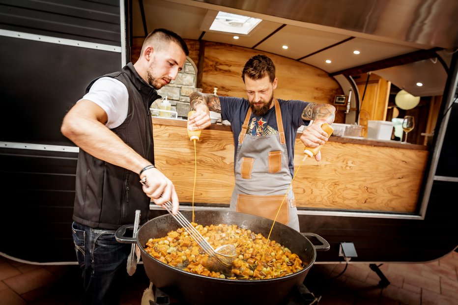 Fotografija: Chef Bine Volič (desno) je skuhal dovolj slastnih jesenskih njokov za tiste, ki so se ta teden pridružili trgatvi v Kleti Brda. FOTO: Damijan Simčič