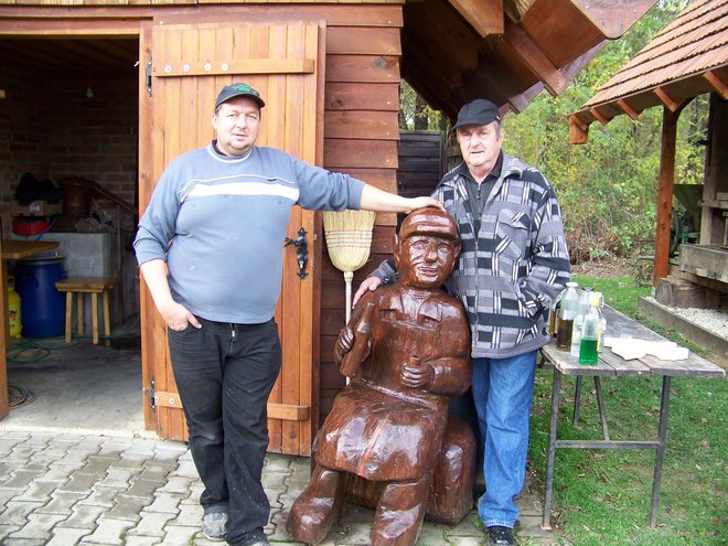 Pred muzejem žganjekuhe stoji iz lesa izdelana maskota.
