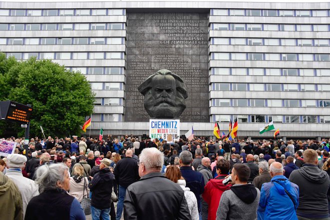 Protestniki so se zbrali pred kipom Karla Marxa, kjer so na preteklih demonstracijah pripadniki skrajne desnice nalepili plakat z napisom: »Chemnitz ni niti siv, niti črn.«  FOTO: John Macdougall/Afp