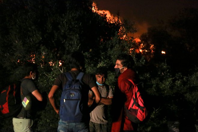 Begunci in migranti so po izbruhu požara zapustili center. FOTO: Manolis Lagoutaris/AFP