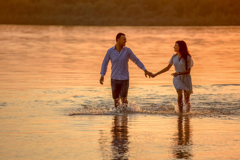 Fotografija: Attractive couple running at the shallow lake water