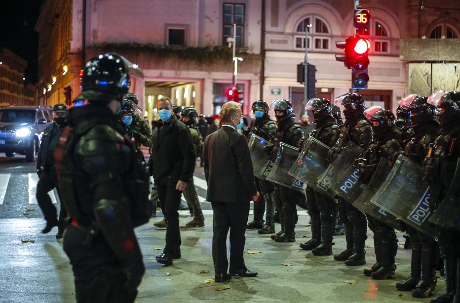 Fotografija: Med lanskimi novembrskimi protesti se je takole zastražen na ulici pojavil minister za notranje zadeve Aleš Hojs. FOTO: Matej Družnik, Delo
