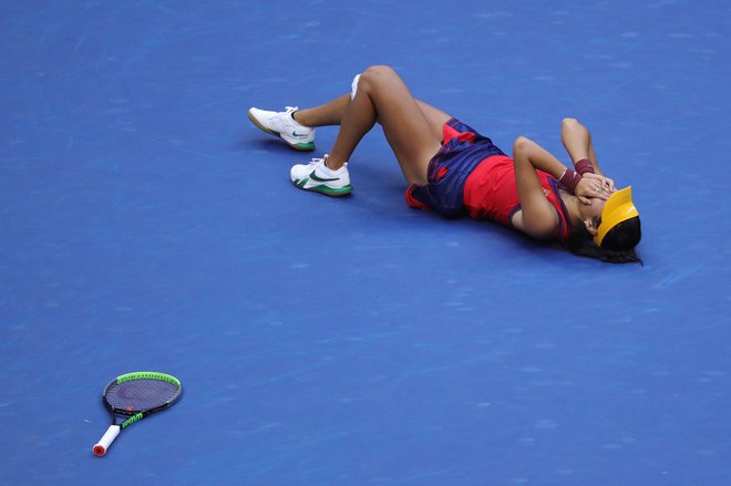 Emma Raducanu je po zmagi padla kot pokošena na tla. FOTO: Kena Betancur/AFP
