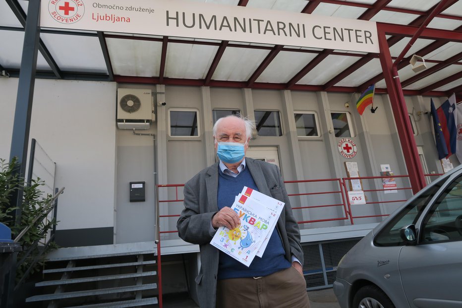 Fotografija: Dobrotnik Milan Kovač pred humanitarnim centrom RKS v Ljubljani z ukrajinskim abecednikom in prvim berilom FOTO: Janez Petkovšek
