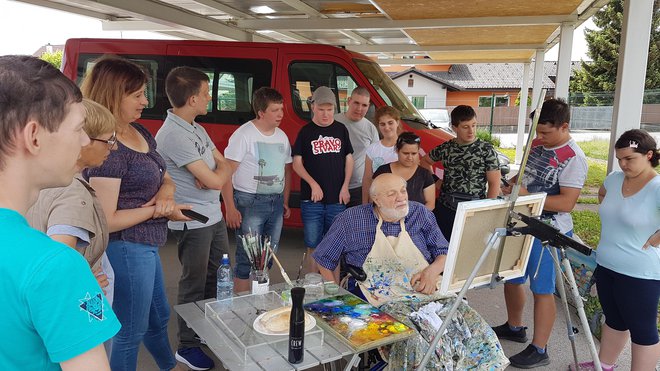 Ustvarjanje invalidov so si z zanimanjem ogledali učenci sosednje šole Osnovne šole Dragotina Ketteja, šole s prilagojenim programom. Kako se slika z usti, jim je pokazal Vojko Gašperut iz Kopra.
