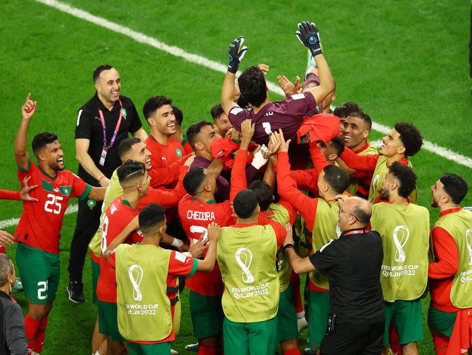 Fotografija: Maroški vratar Yassine Bounou je končal na rokah rojakov kot dan prej Hrvat Dominik Livaković. Maročani se bodo v soboto (16.00) pomerili z boljšim iz dvoboja med Portugalsko in Švico. FOTO: Lee Smith/Reuters
