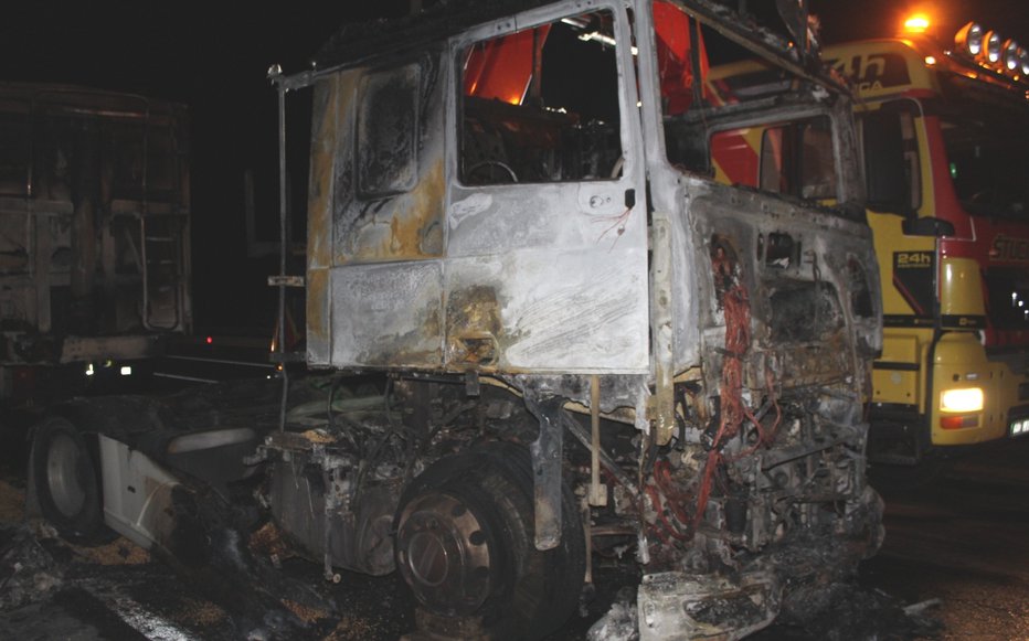 Fotografija: V požaru je v celoti pogorelo vlečno vozilo, prav tako je pogorel tudi del prikolice, na kateri je bil naložen razsuti tovor. FOTOGRAFIJI: PP Nova Gorica

