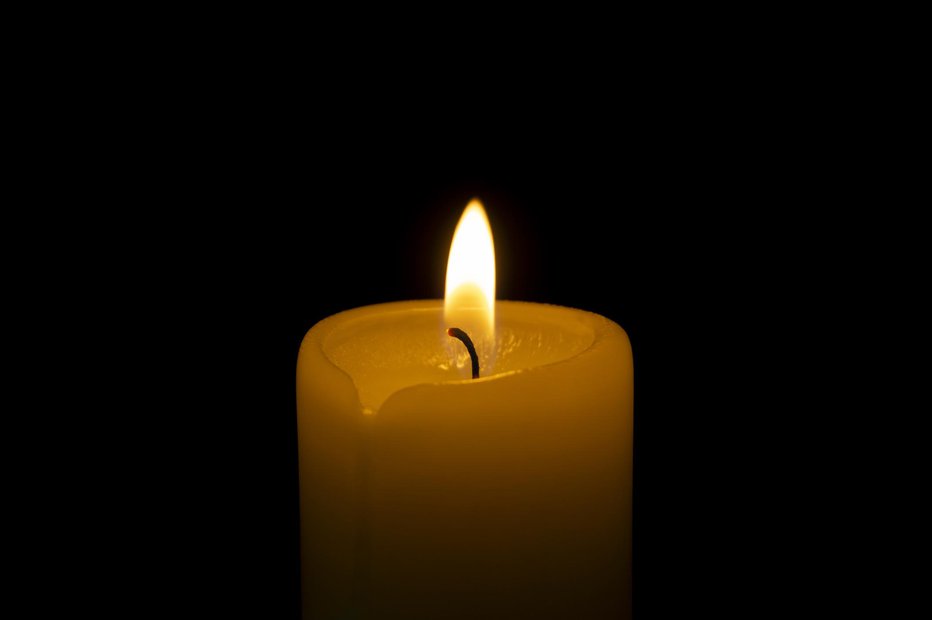 Fotografija: Close up of orange wax candle flame on a dark background FOTO: Getty Images/istockphoto