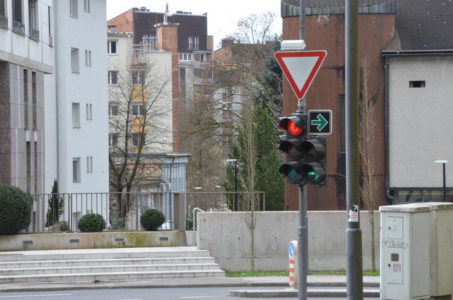 Zahtevna situacija, kjer imamo semafor za zavijanje desno in na njem še znak z zeleno puščico na črni podlagi.