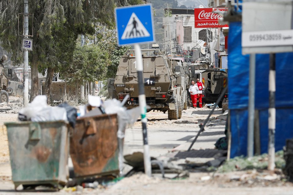 Fotografija: Delavci Rdečega križa med izraleskimi tanki v begunskem taborišču Nur Šams. FOTO: Raneen Sawafta Reuters