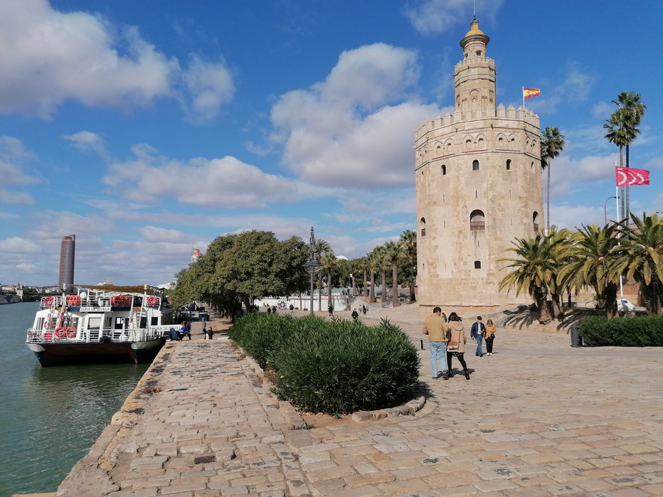 Fotografija: Torre del Oro ali Zlati stolp je bil z namenom nadzorovati dostop do Seville prek reke Guadalquivir, zgrajen v začetku 13. stoletja. Zakaj zlati? Najbrž zaradi pozlačenih keramičnih ploščic, ki so sprva krasile ta stolp z dvanajstimi oglišči, povsem mogoče pa je tudi, da so ga za »zlatega« razglasili, ker so v času, ko je imela Sevilla monopol nad trgovino z »Novim svetom«, v njem hranili zlato in druge plemenite kovine. FOTO: Gorazd Dominko