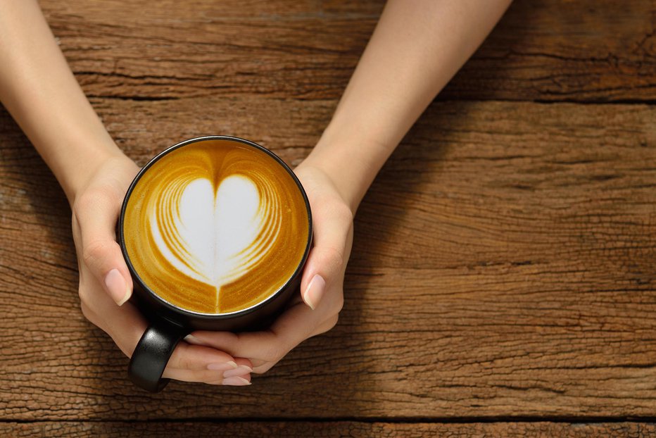 Fotografija: Woman holding cup of coffee latte, with heart shape FOTO: Amenic181 Getty Images/istockphoto