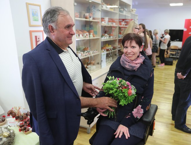 Odgovorni urednik Slovenskih novic Bojan Budja predaja šopek rož umetnici Beti Lunder iz Dobrepolja. FOTO: Dejan Javornik