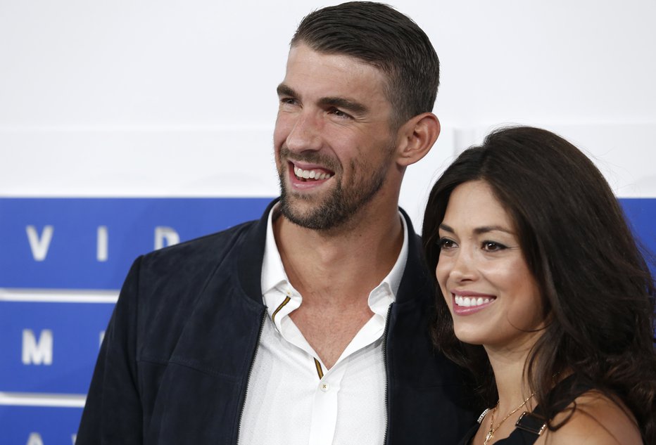 Fotografija: Michael Phelps z ženo Nicole poskuša pomagati mladim športnikom. FOTO: Reuters