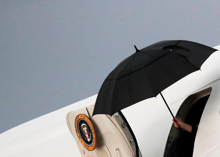 Fotografija: Trump je poskrbel, da se njegovi lasje ne bodo zmočili. FOTO: Reuters