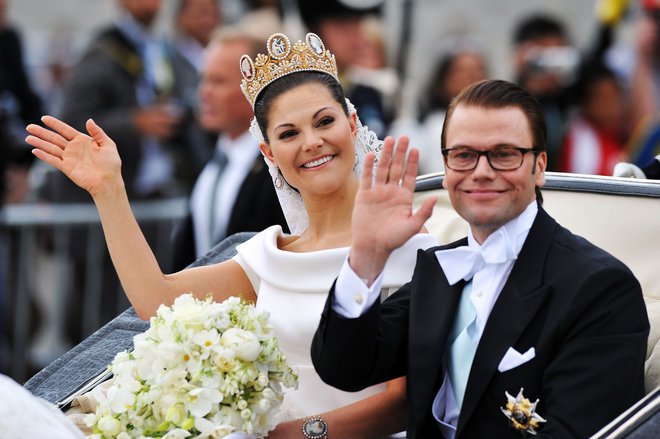 Po obredu sta se švedska prestolonaslednica Viktorija in njen mož Daniel po Stockholmu popeljala s kočijo. FOTO: Getty Images