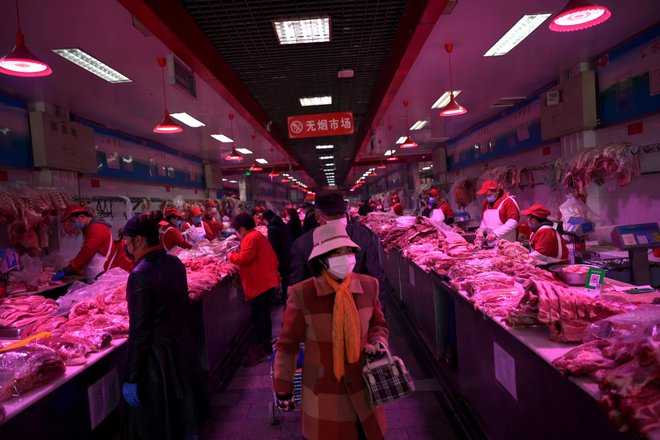 Slovito tržnico so zaprli, virus naj bi odkrili na deskah za rezanje lososa. FOTO: Tingshu Wang/Reuters