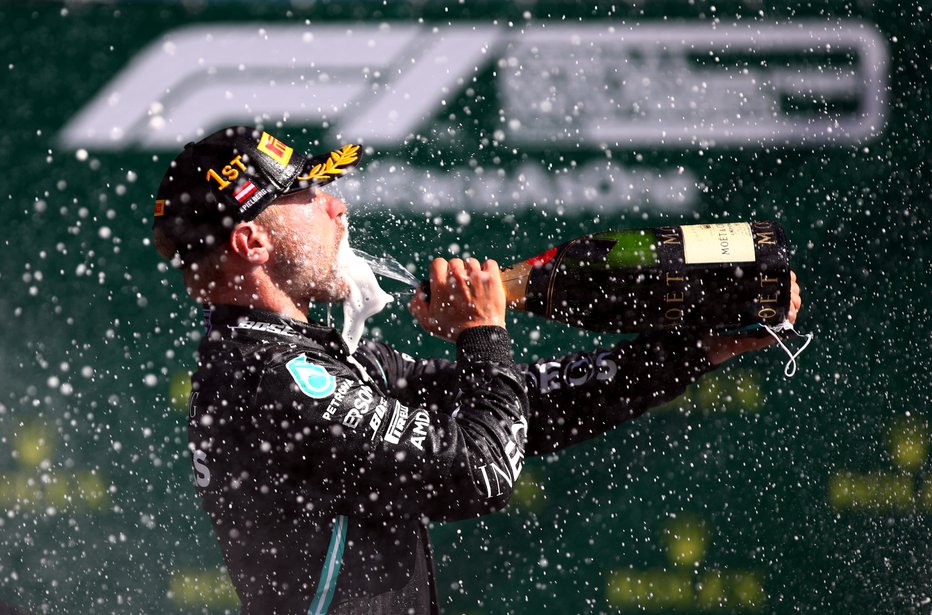 Fotografija: Dirkači pravzaprav ves čas nosijo zaščitne maske, finski as Valtteri Bottas si jo je za trenutek odstranil le, da si je privoščil požirek zmagovitega šampanjca. FOTO: Mark Thompson/Reuters