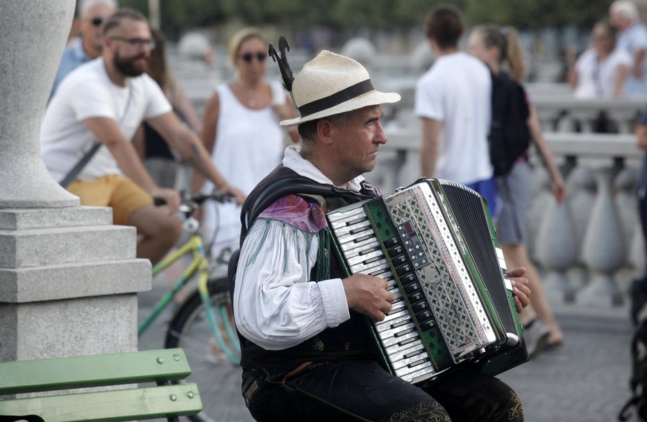 Fotografija: Harmonikar Marko že leta preigrava glasbo v slovenski narodni noši. FOTO: Mavric Pivk, Delo