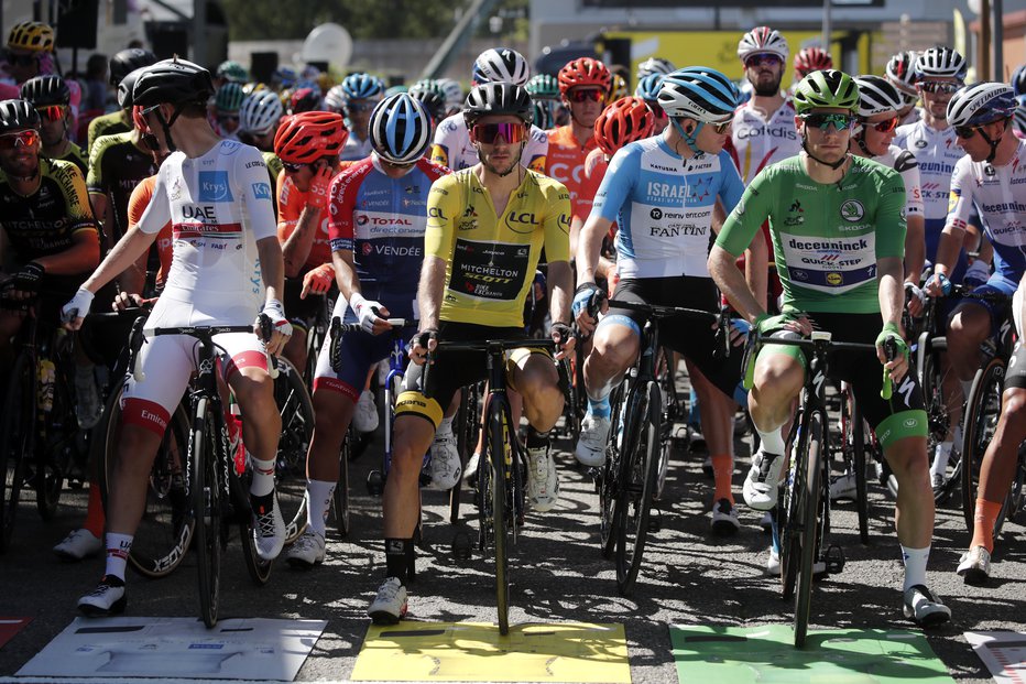 Fotografija: Tadeja Pogačarja (levo), ki nosi belo majico najboljšega mladega kolesarja, včeraj še ni zanimala rumena majica Adama Yatesa. FOTO: Benoit Tessier/Reuters
