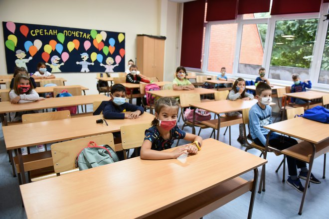 Vrnitev v šolske klopi je bila v začetku letošnjega šolskega leta za otroke po svetu precej drugačna kot v preteklih letih. Pri nas otrokom v učilnicah ni treba nositi mask, drugače pa je na primer v Srbiji. FOTO: Zorana Jevtic, Reuters