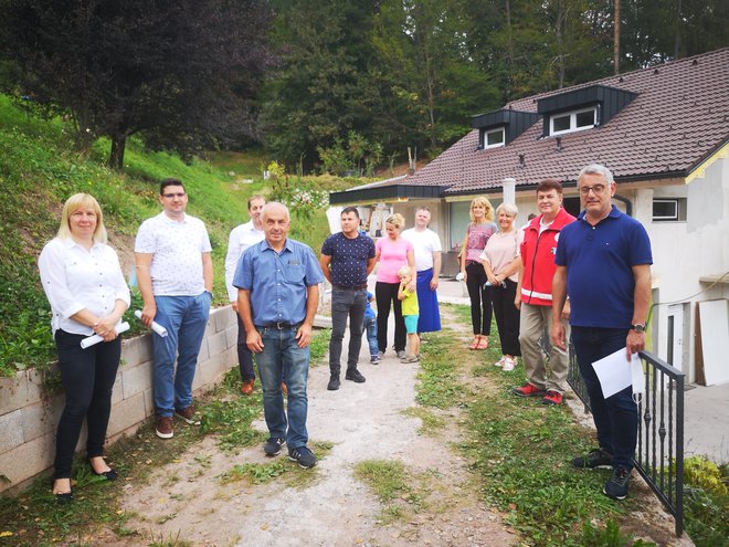 Pred obnovljeno hišo zaslužni za hitro pomoč osemčlanski družini. Med temi sta tudi Maja Gerčer Špitalar (prva z leve) ter poslanec Matjaž Han (desno). FOTO: Mojca Marot