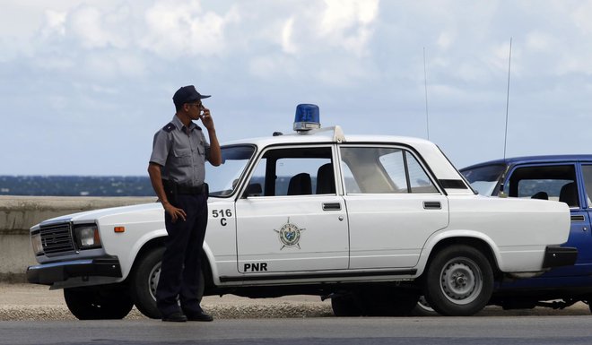 Ladin legendarni model je pripraven za vse, tudi za policijski avto na Kubi. FOTO: Desmond Boylan/reuters