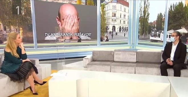 Ana Tavčar z gostom, ki je imel masko in je sedel nekaj metrov stran, med njima pa pleksi steklo. FOTO: RTV Slovenija, posnetek zaslona