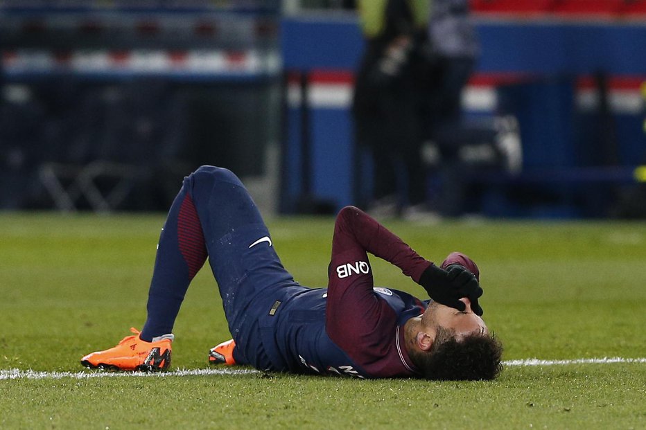 Fotografija: PSG's Neymar lays on the pitch after being fouled during the French League One soccer match between Paris Saint-Germain and Marseille at the Parc des Princes Stadium, in Paris, France, Sunday, Feb. 25, 2018. (AP Photo/Thibault Camus)
