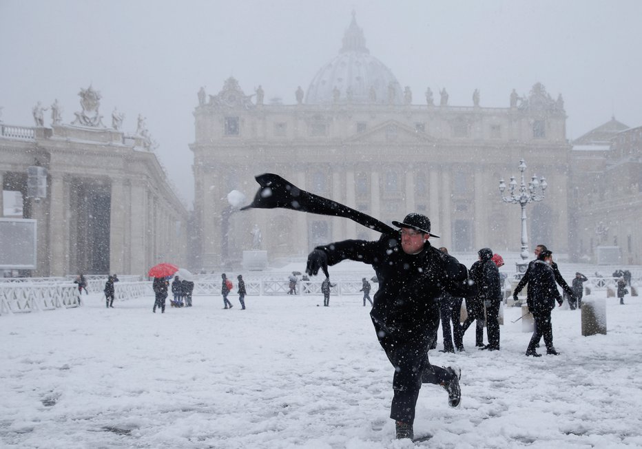 Fotografija: Sneg je pobelil tudi vatikanski trg sv. Petra, duhovniki so se kepali. FOTO: Reuters