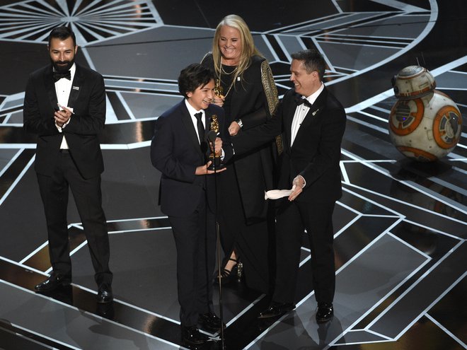 Z leve proti desni: Adrian Molina, Anthony Gonzalez, Darla K. Anderson in Lee Unkrich, ki so prevzeli nagrado za nagrajeni animirani film Coco. FOTO: Chris Pizzello, AP