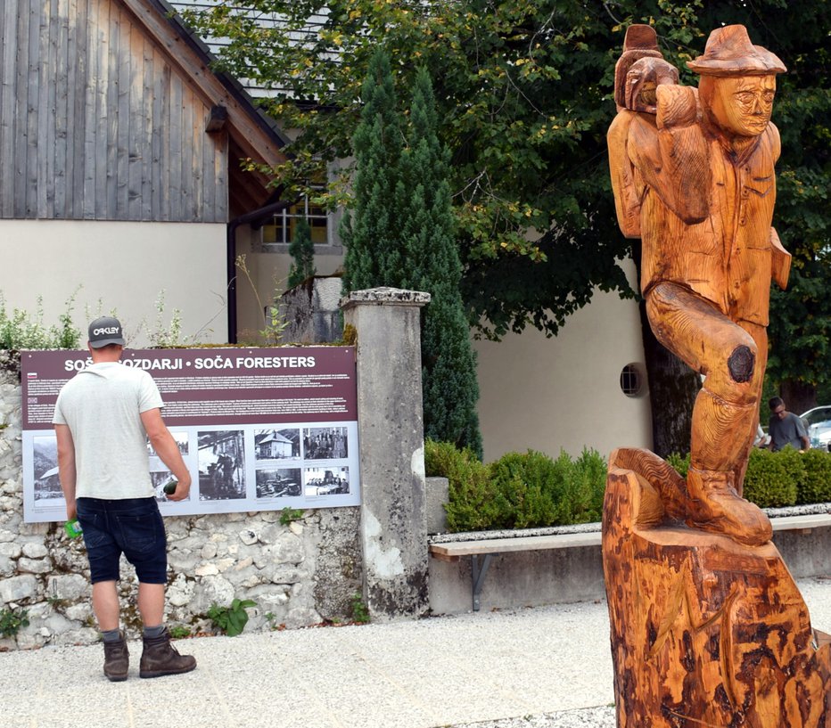 Fotografija: Lesena skulptura stoji na prostoru med vaško trgovino in župnijsko cerkvijo sv. Jožefa. Foto: Boris Dolničar