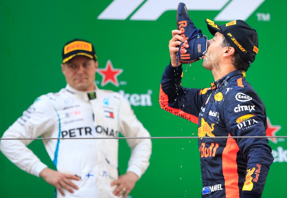 Fotografija: Daniel Ricciardo (desno, ob njem Valtteri Bottas) je šanghajsko zmago proslavil v zanj značilnem slogu – s pitjem šampanjca iz svojega dirkalnega copata. FOTO: Reuters