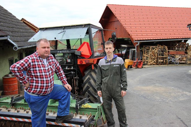 Darko in Klemen ob traktorju, zadaj nov kozolec, stari je pogorel. FOTO: Tanja Jakše Gazvoda