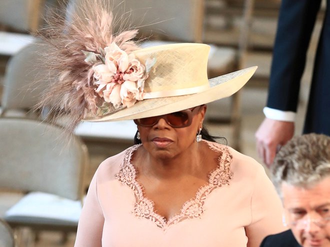 Oprah Winfrey nosi roza obleko in klobuk. FOTO: Reuters