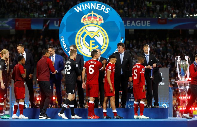Liverpoolovi igralci iz rok Aleksandra Čeferina prejemajo medalje za drugo mesto. FOTO: Kai Pfaffenbach, Reuters