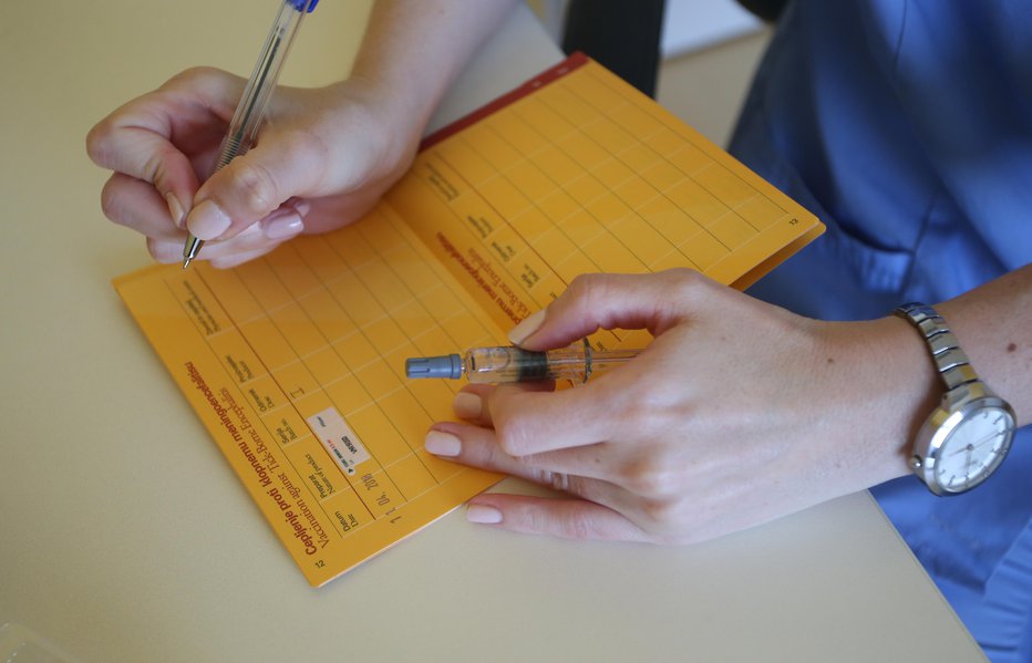 Fotografija: Opravljena cepljenja pediater zapiše v rumeno knjižico. FOTO: Tadej Regent, Delo