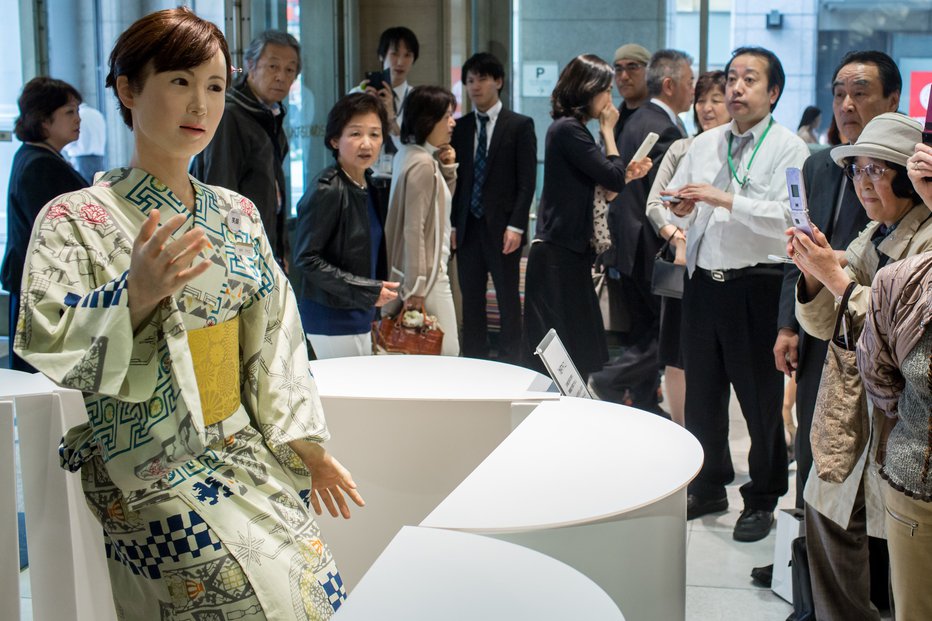 Fotografija: V eni od tokijskih trgovin robotka dela na recepciji. FOTO: Guliver/getty Images