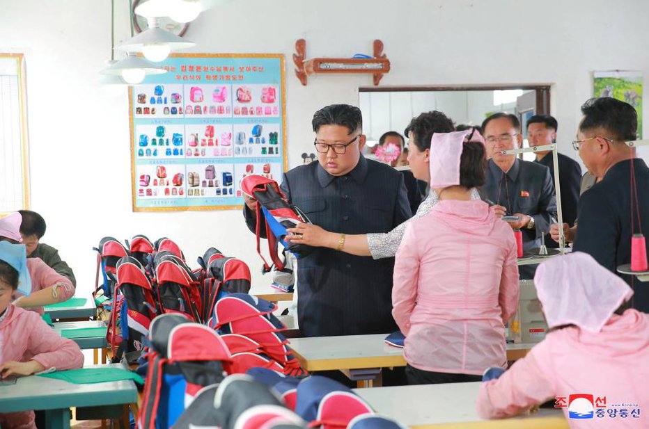 Fotografija: Kim je v tovarni torb pozorno pregledal izdelke. FOTO: Reuters