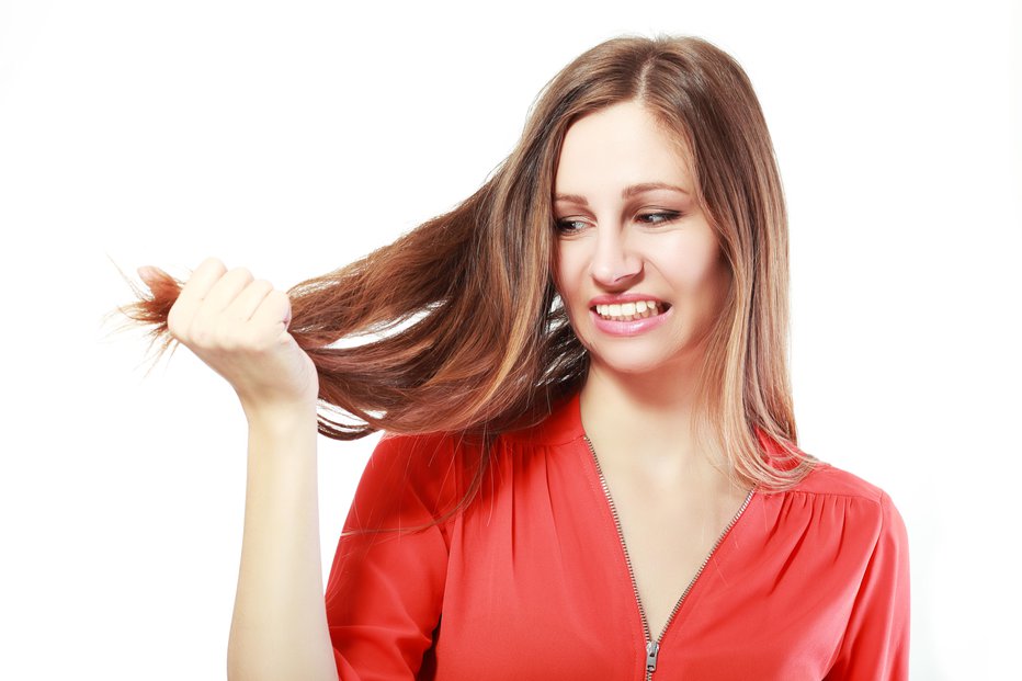Fotografija: woman is not happy with her fragile hair, white background, copyspace