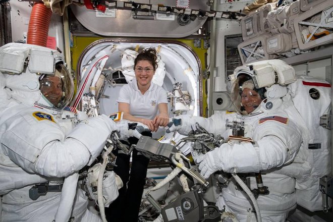 Christina Koch (na sredini) pomaga Nicku Hagueju (levo) in Anne McClain, tik preden sta opravila vesoljski sprehod. FOTO: Nasa