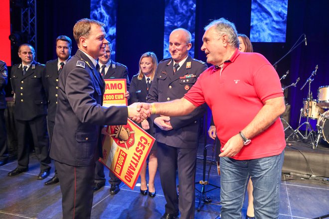 Odgovorni urednik Slovenskih novic Bojan Budja je gasilcem PGD Starše in PGD Hajdoše izročil nagrado.