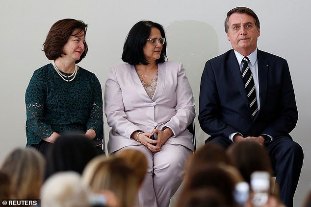 Predsednik Jair Bolsonaro (desno) sedi ob ministrici Damares Alves. FOTO: Reuters